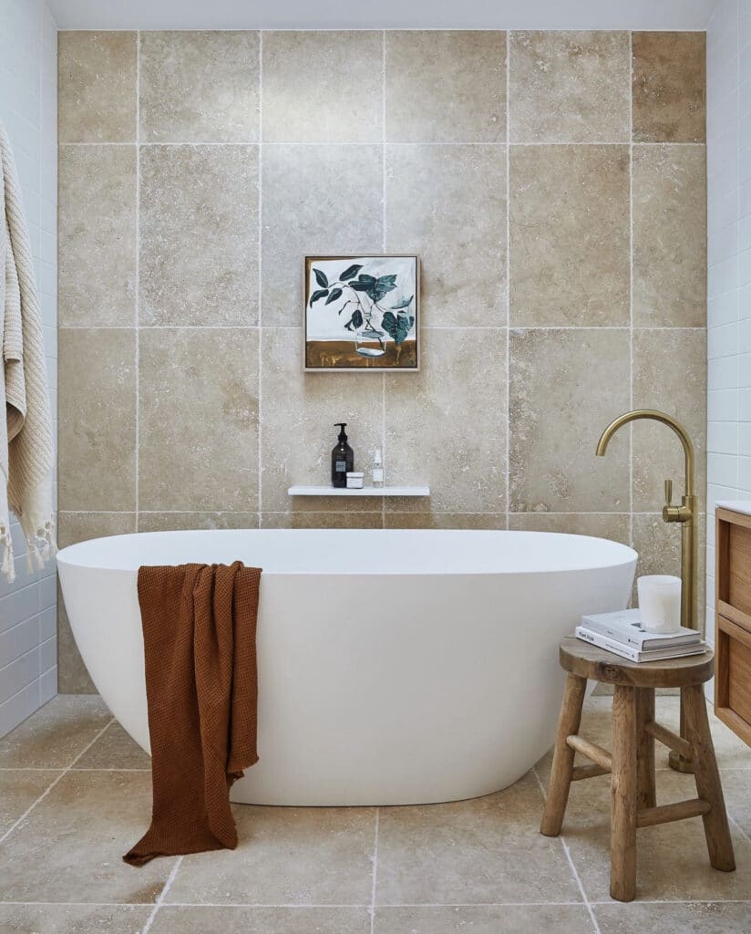 white bath tub with tile bath wall